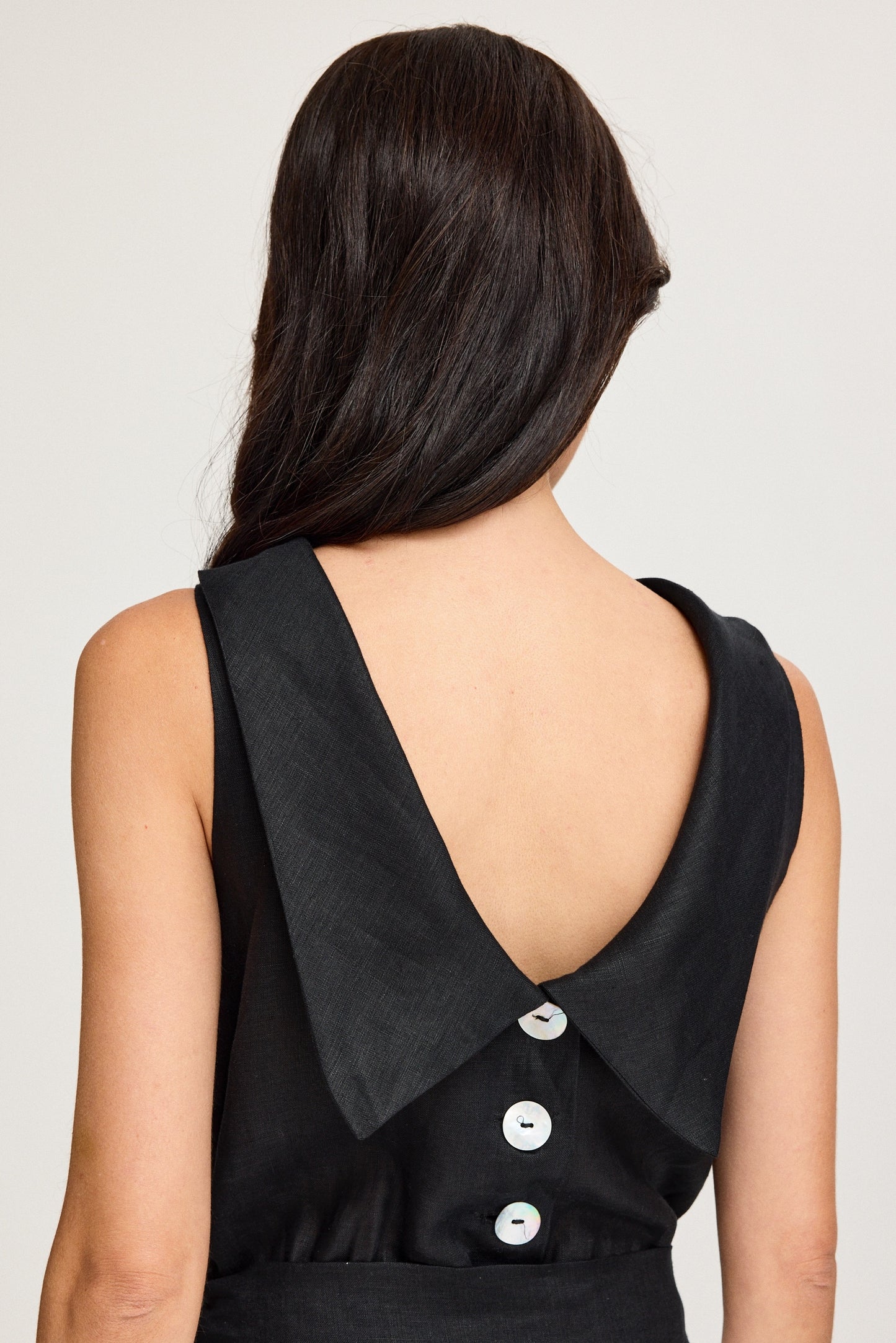 Black sleeveless top with a unique collar design on a plain background Black & White