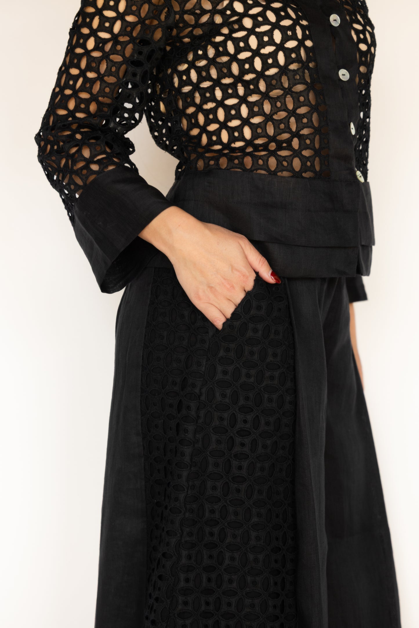 Black outfit with intricate cut-out design on a plain background