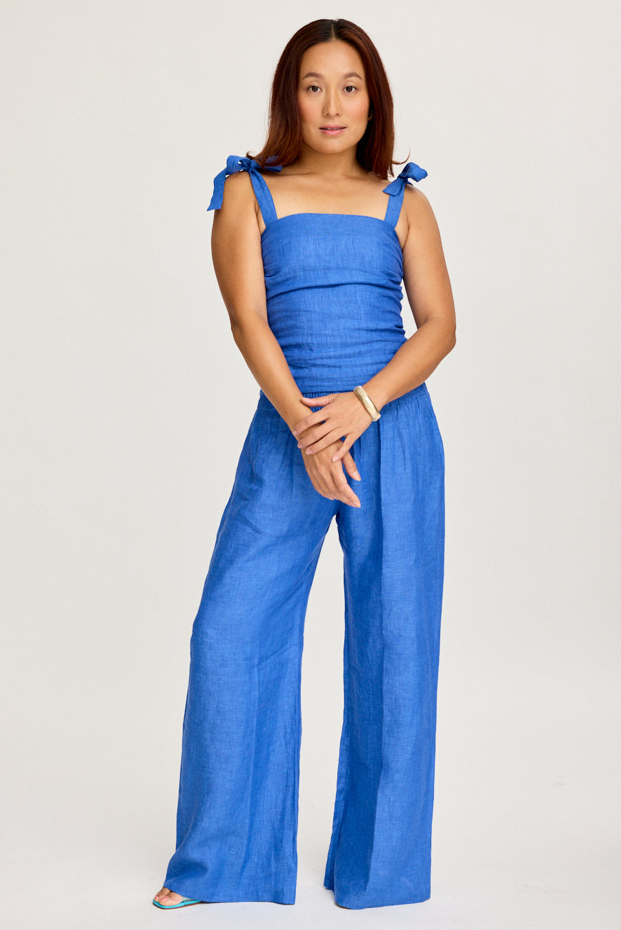 Woman wearing a blue set on a light gray background