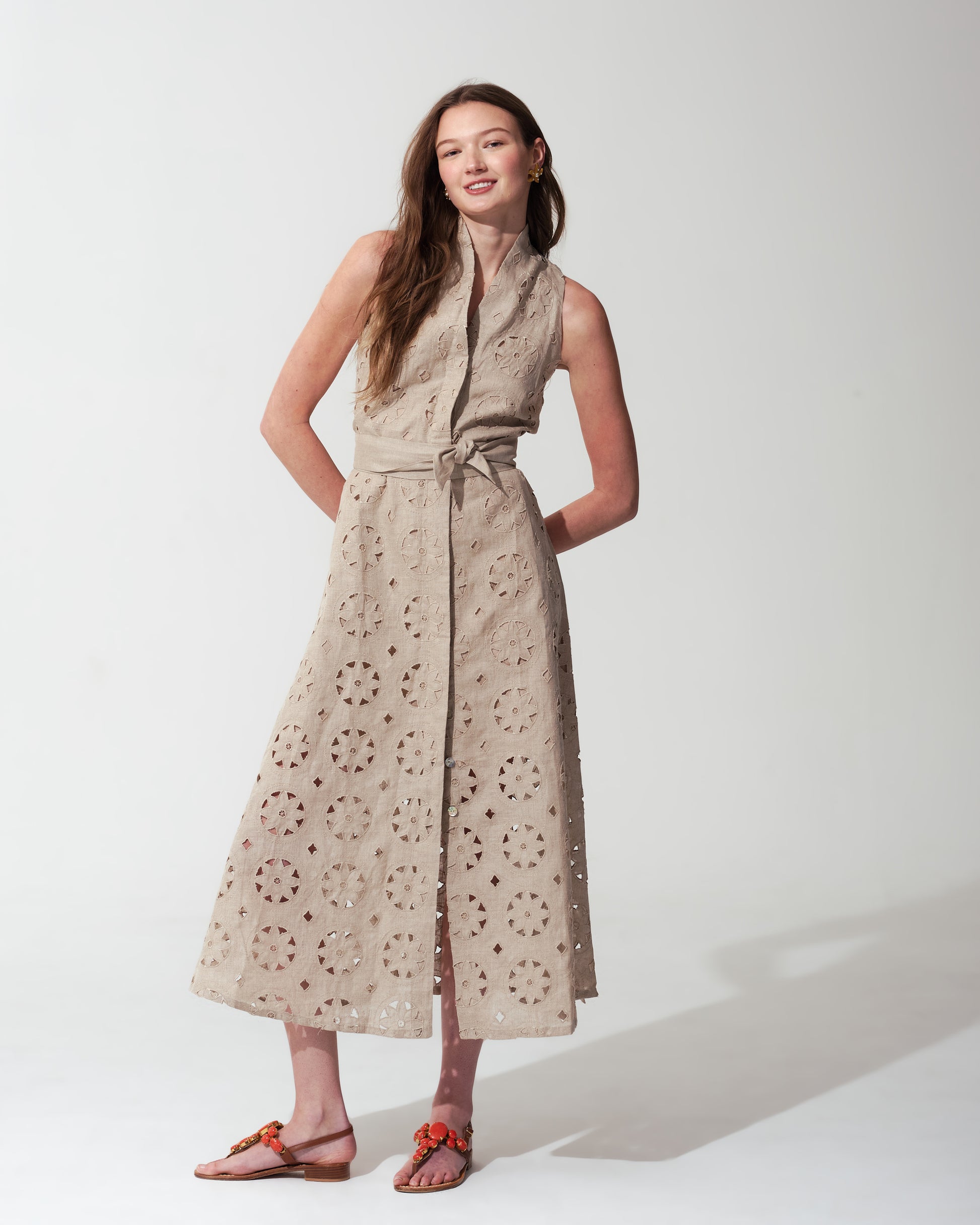 Woman wearing a Sand sleeveless dress with a subtle pattern on a background