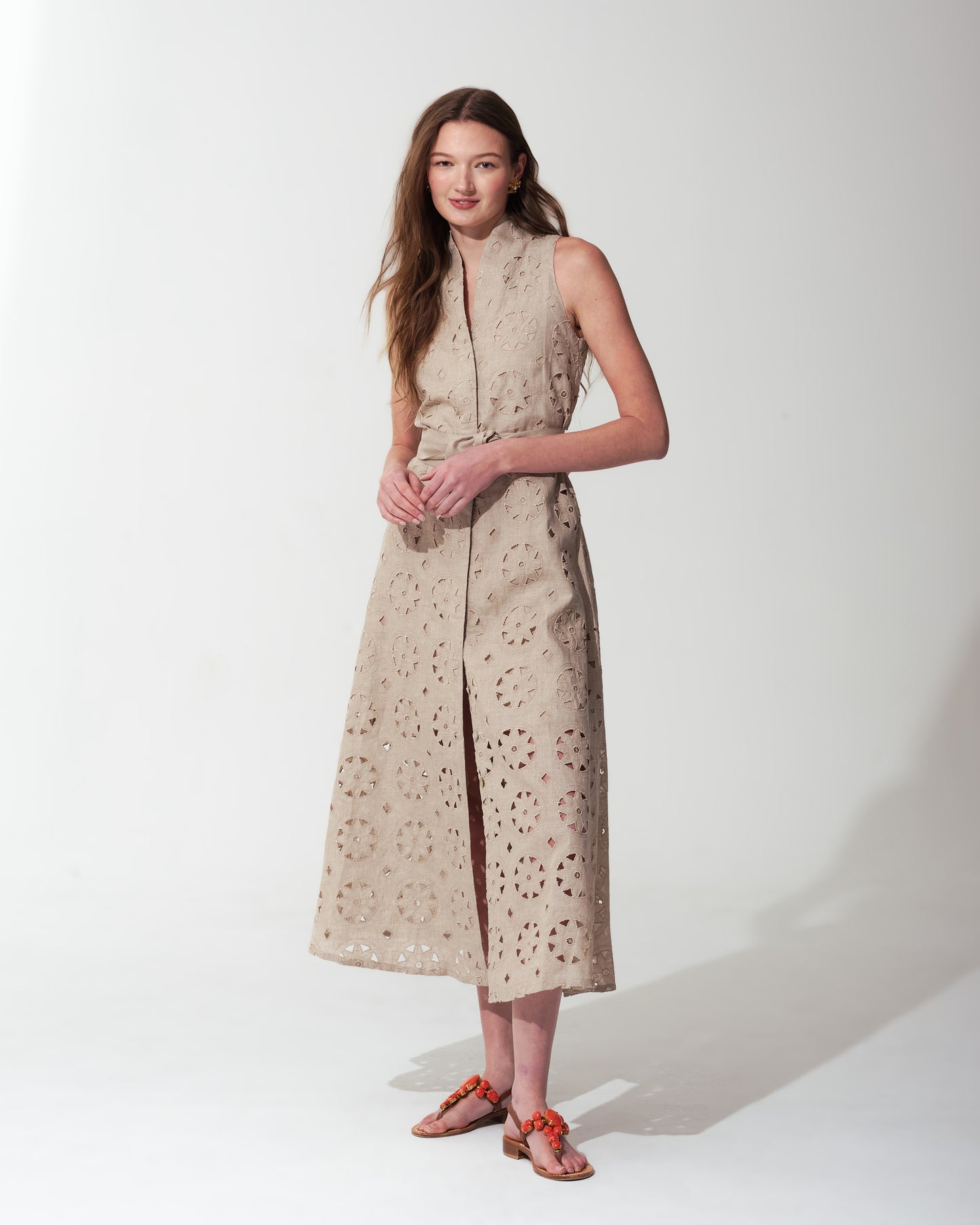 Woman wearing a Sand sleeveless dress with a subtle pattern on a  background