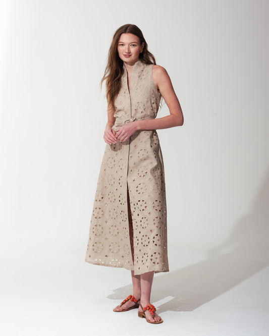 Woman wearing a Sand sleeveless dress with a subtle pattern on a  background