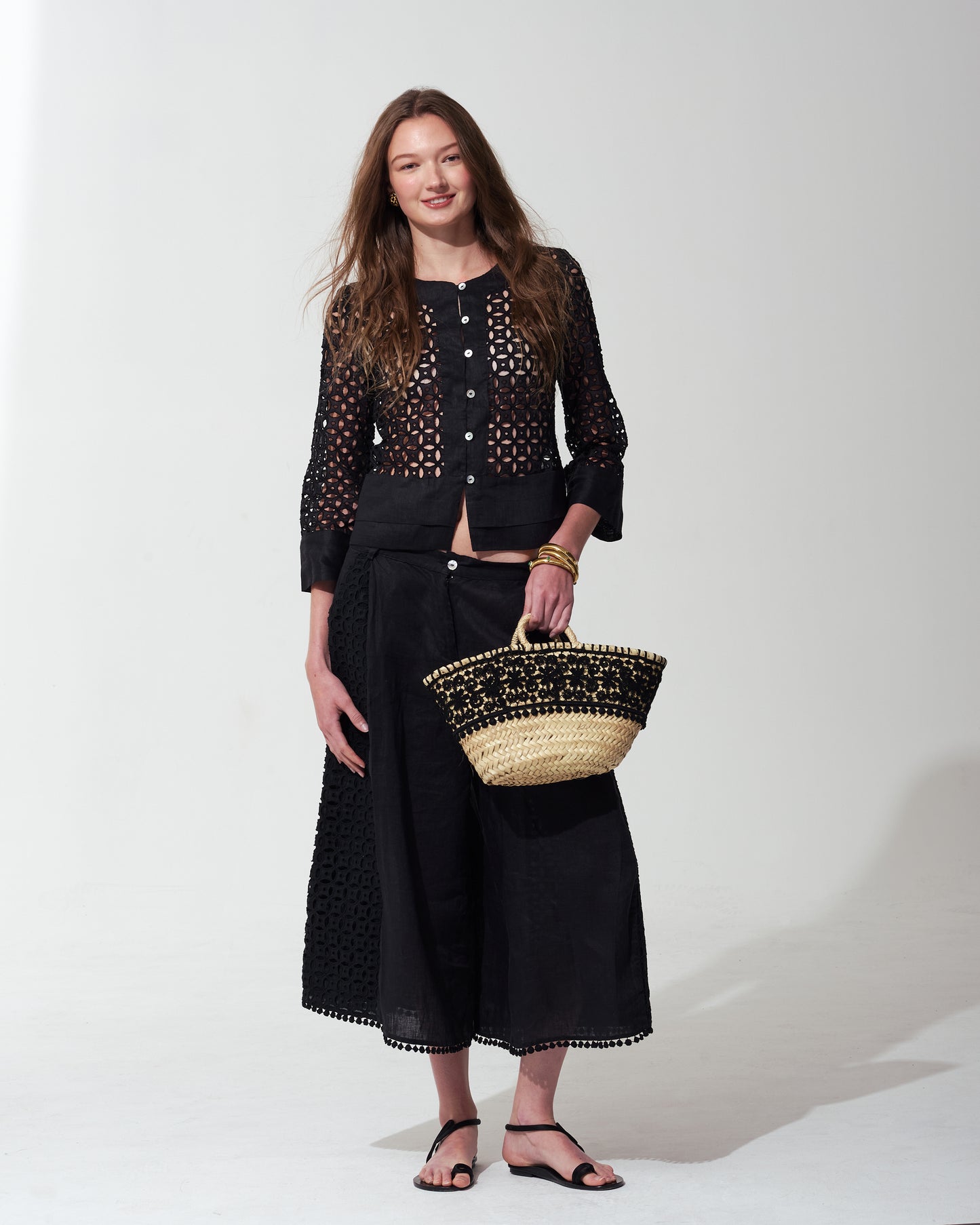 Woman wearing a black outfit with a textured bag on a  background