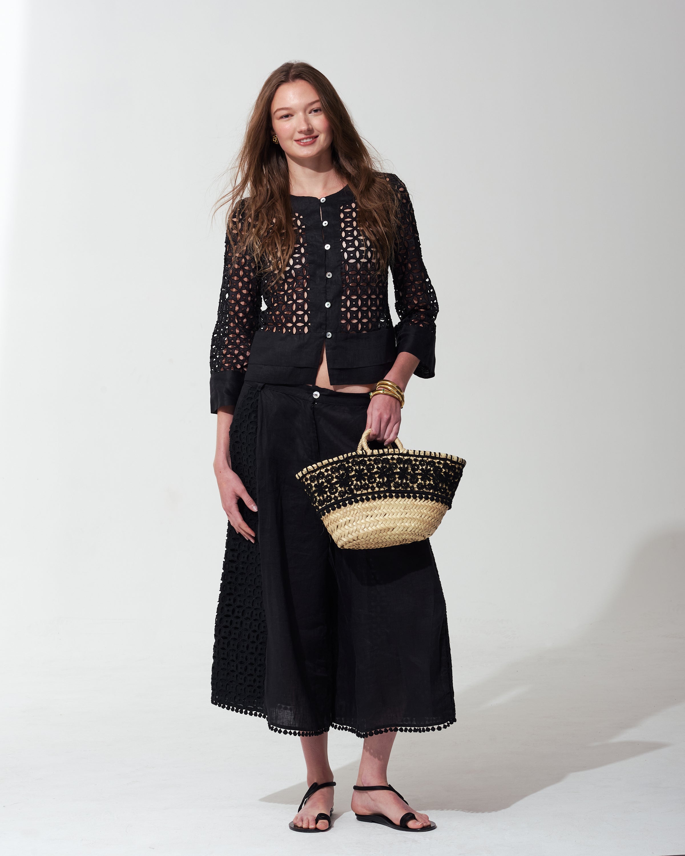 Woman wearing a black outfit with a textured bag on a  background