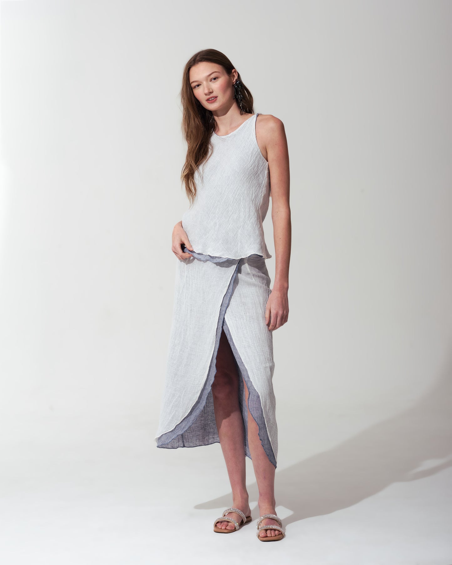 Woman wearing a sleeveless top and skirt set on a White background