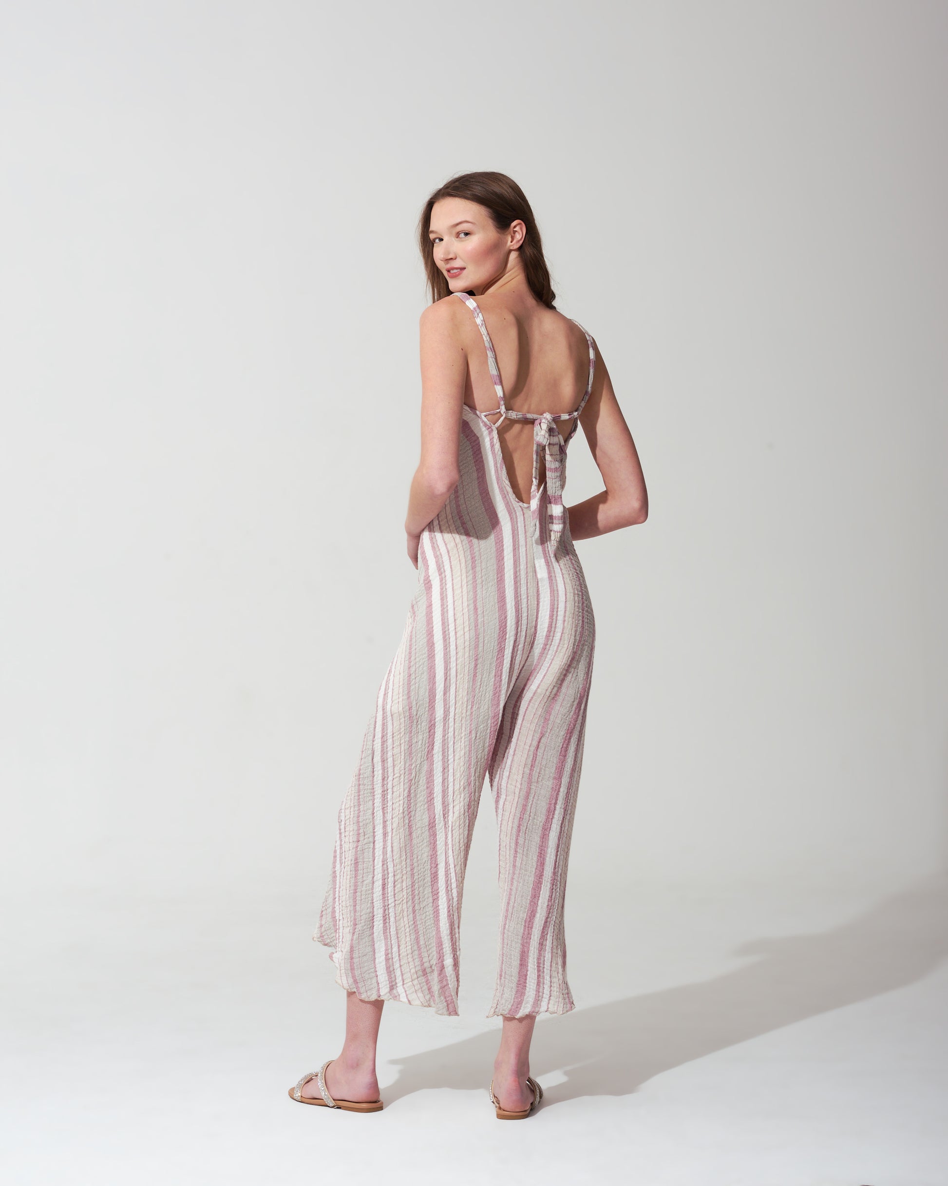 Woman wearing a striped pink jumpsuit on a  background