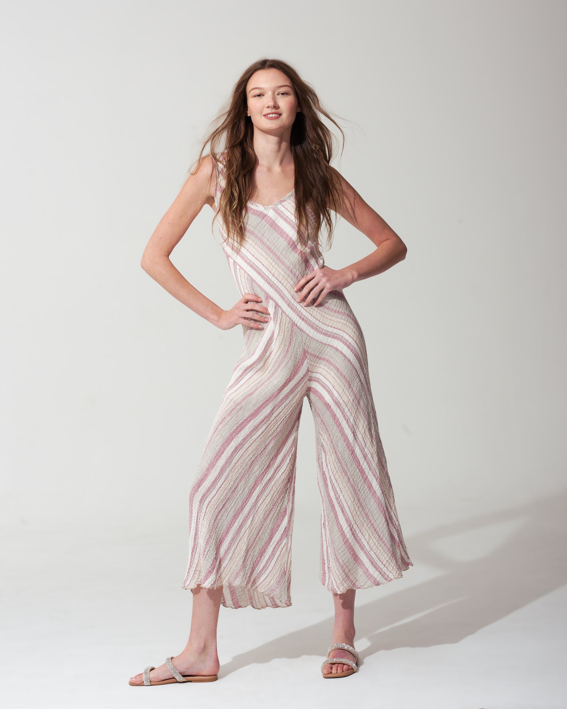 Woman wearing a striped pink jumpsuit on a  background