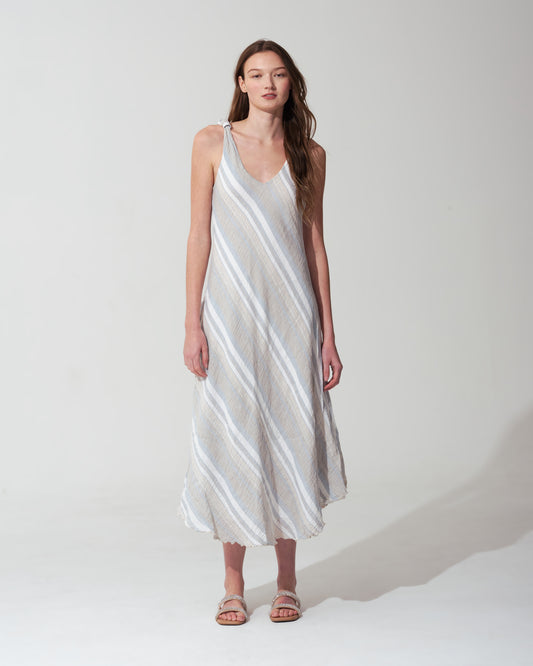 Woman wearing a white and gray striped  blue dress on a white background