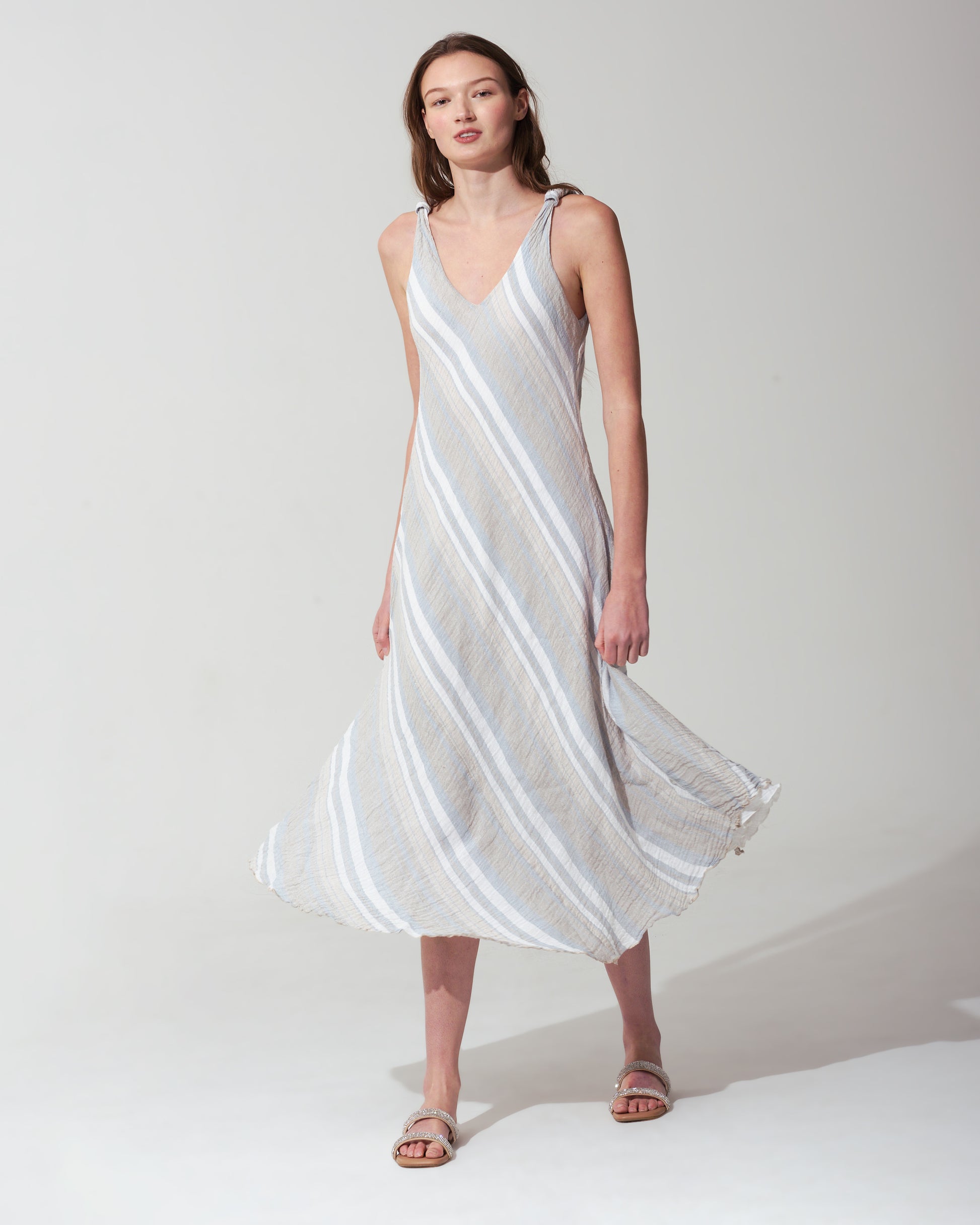 Woman wearing a striped blue dress against a plain background