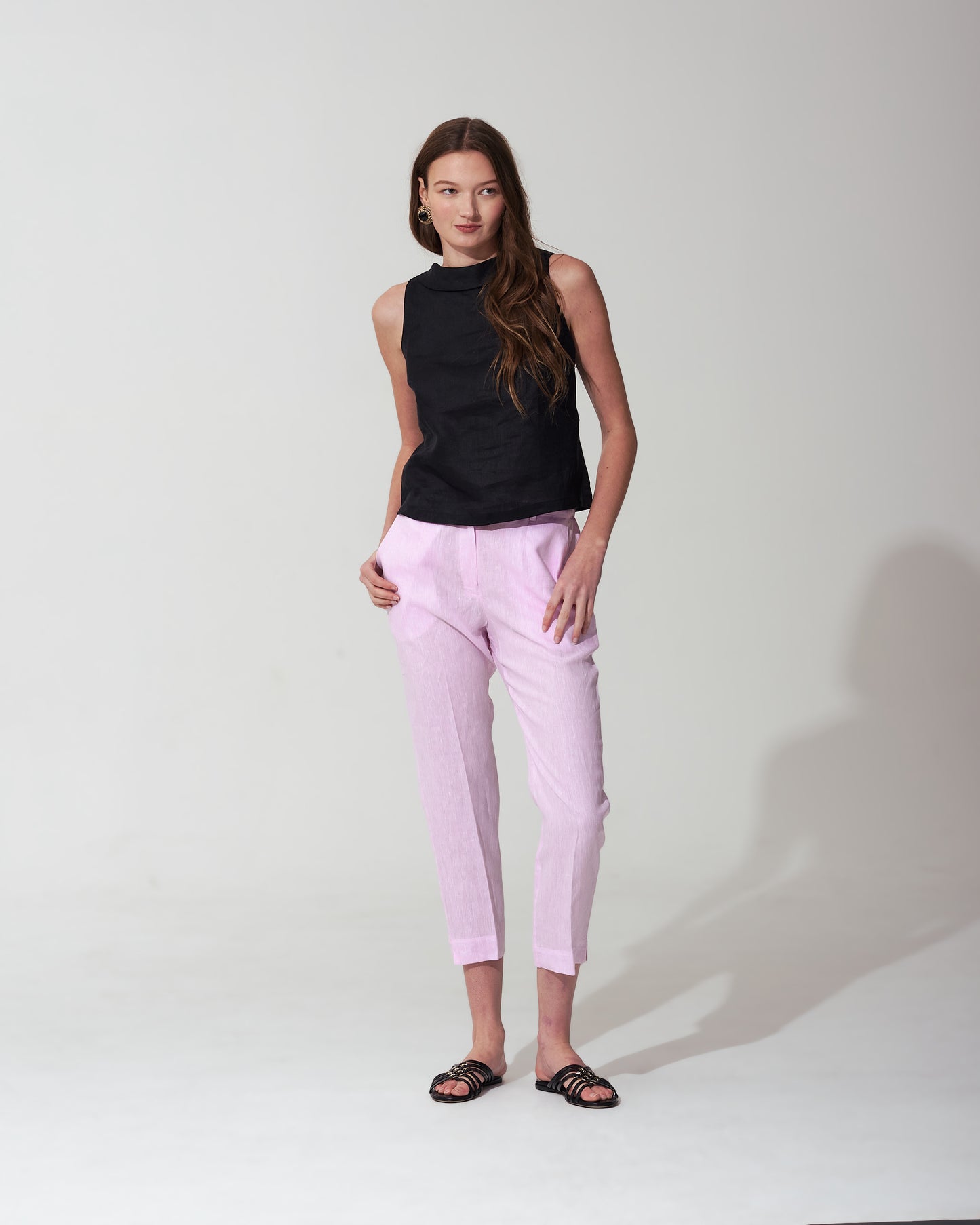 Woman wearing a  Pastel Pink and pink pants against a background