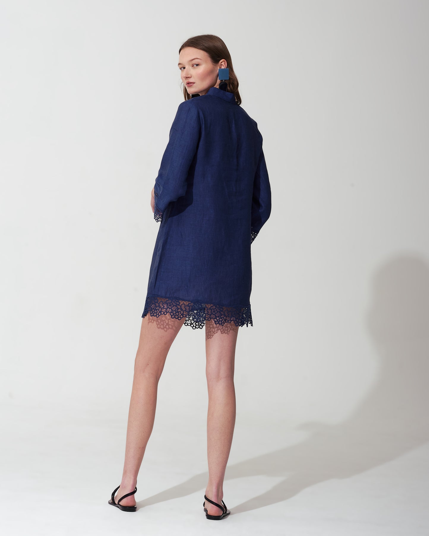 Woman wearing a  blue royal dress with lace details on a  background