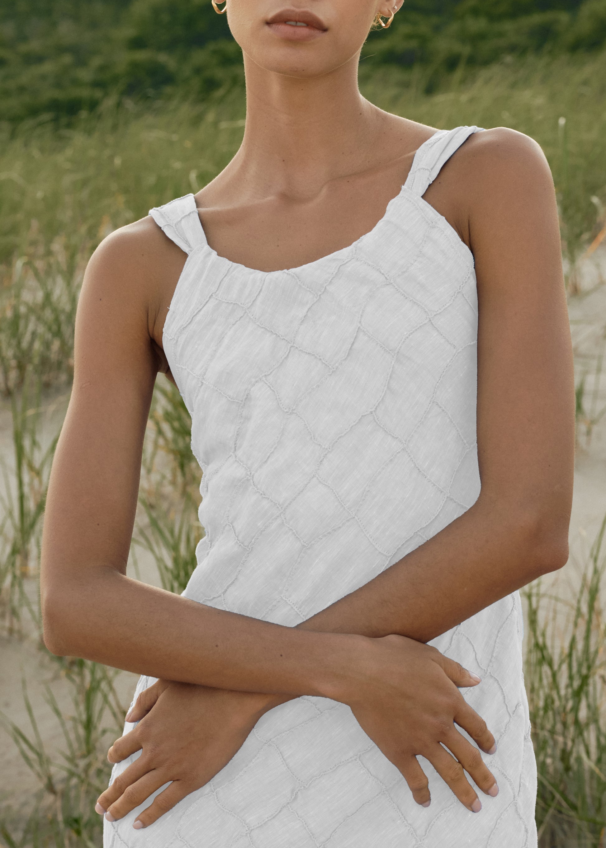 Woman wearing a White quilted dress standing in a natural setting